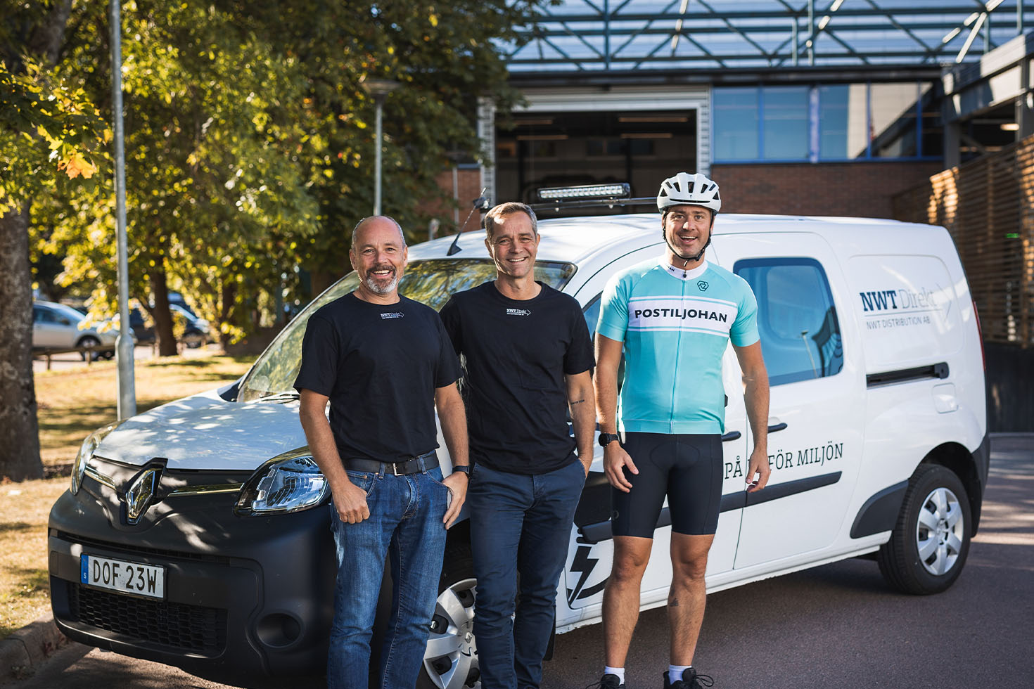 tre logistikmedarbetare poserar glatt framför Budbil